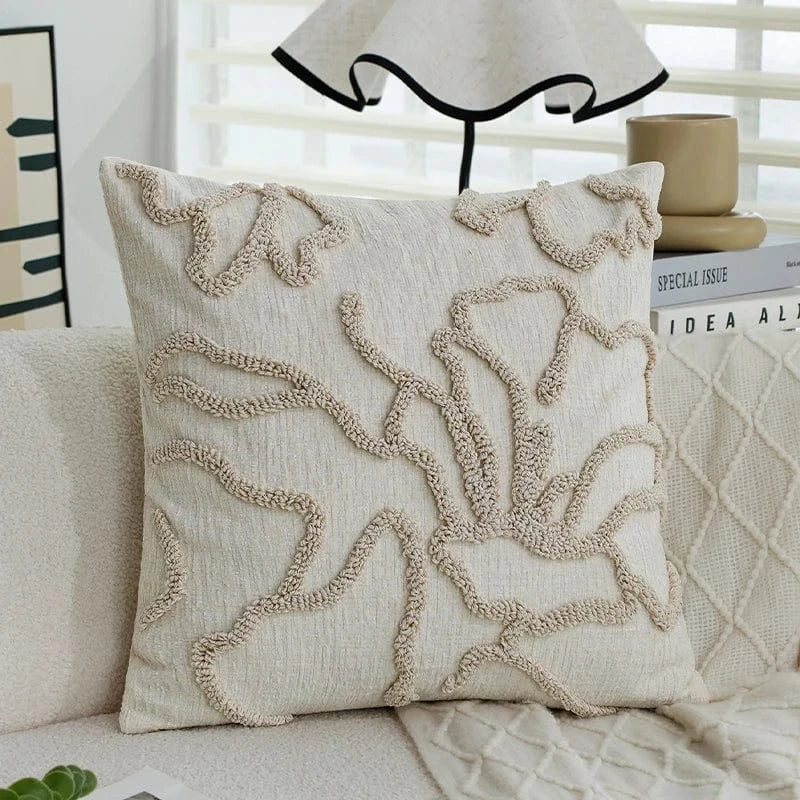 Coussin décoratif beige avec motifs texturés sur un canapé moderne, apportant une touche élégante à l'intérieur