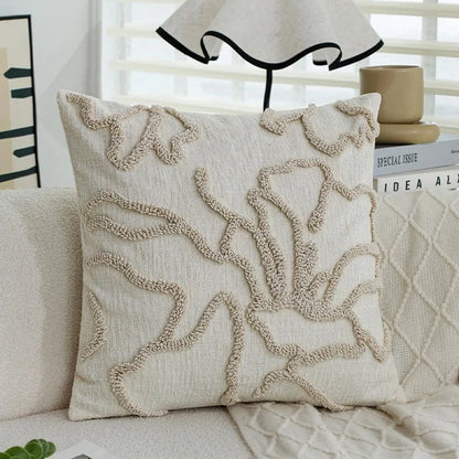 Coussin décoratif beige avec motifs texturés sur un canapé moderne, apportant une touche élégante à l'intérieur