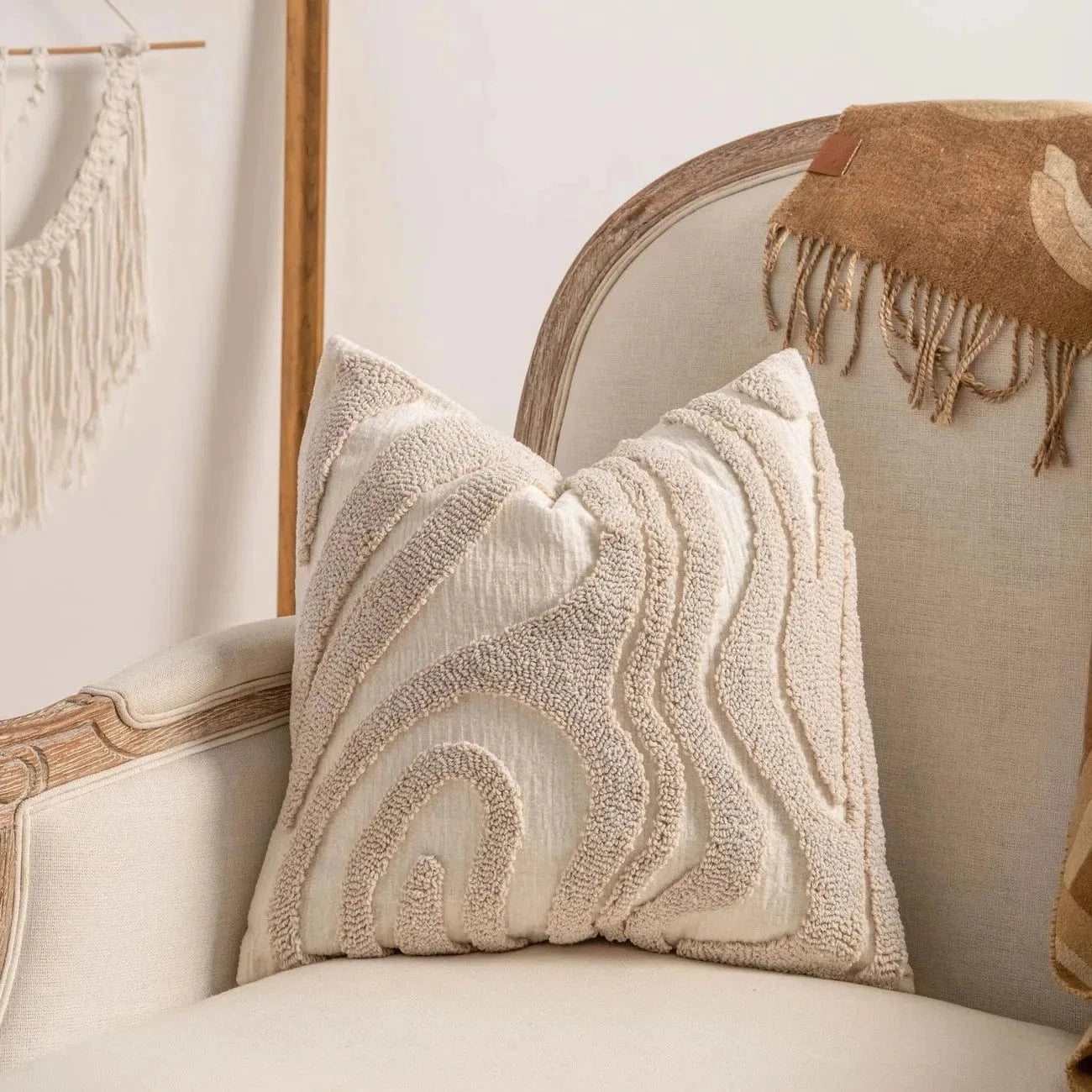 Coussin décoratif en tissu beige avec motifs géométriques sur un fauteuil élégant dans un salon moderne