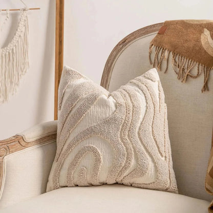 Coussin décoratif en tissu beige avec motifs géométriques sur un fauteuil élégant dans un salon moderne