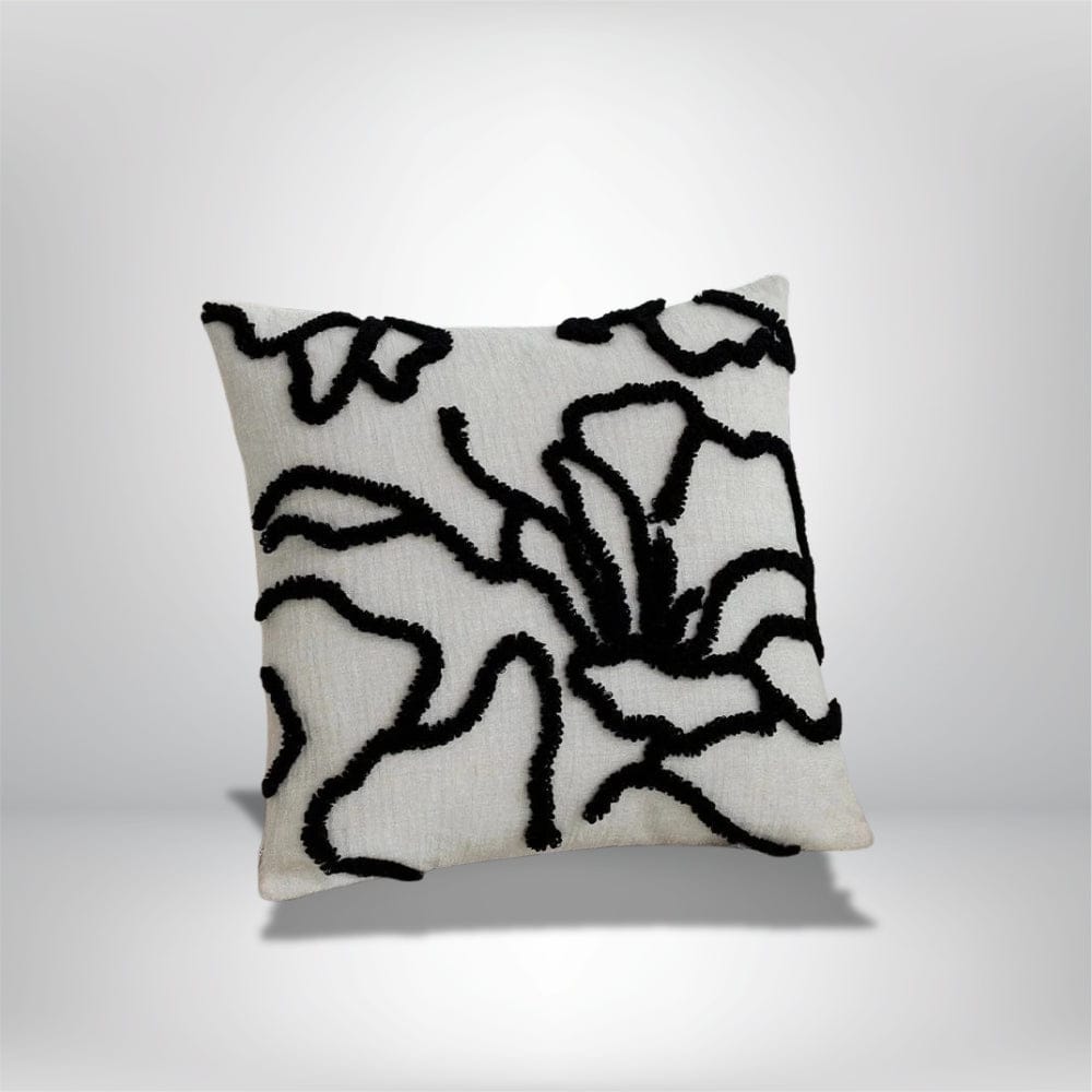 Coussin décoratif avec motifs floraux en noir sur fond beige, idéal pour un canapé moderne