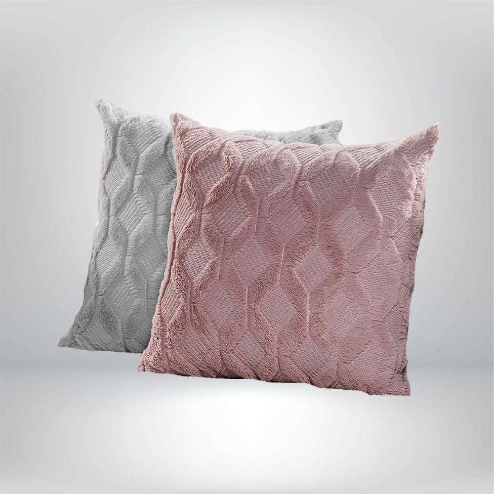 Deux coussins décoratifs en velours, l'un rose et l'autre gris, avec un motif texturé, posés sur un fond neutre