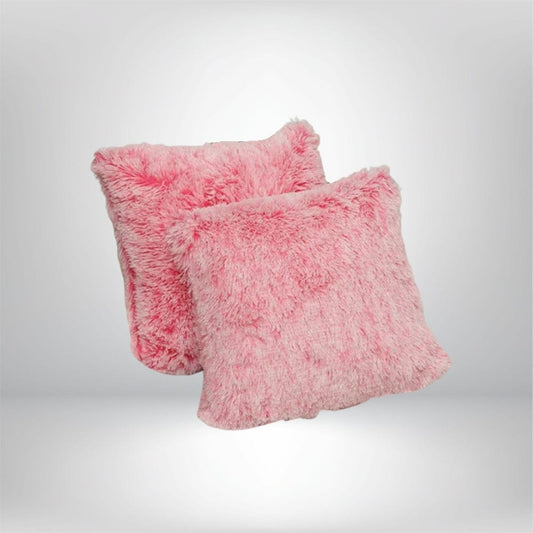 Coussins décoratifs en fausse fourrure rose, posés sur un fond neutre, apportant une touche chaleureuse à votre salon