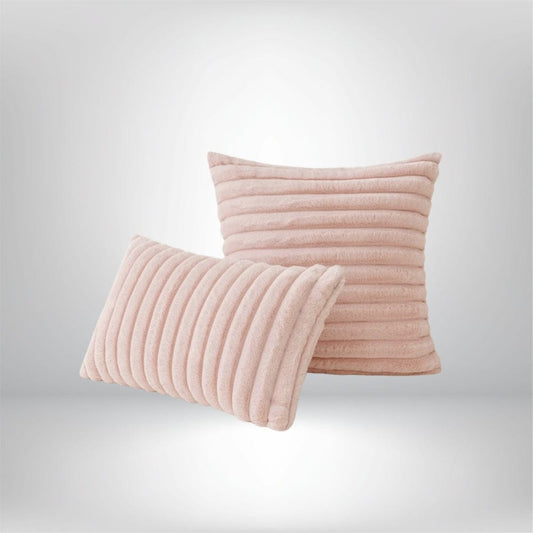 Deux coussins décoratifs en fourrure rose, l'un à rayures et l'autre rectangulaire, sur un fond neutre