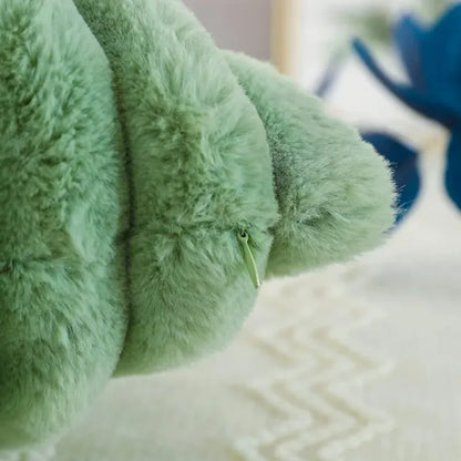 Housse de coussin en fourrure verte posée sur une surface claire, apportant une touche douce et chaleureuse à la décoration