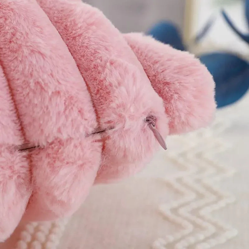 Housse de coussin en fourrure rose sur une surface douce, ajoutant une touche chaleureuse à votre décor