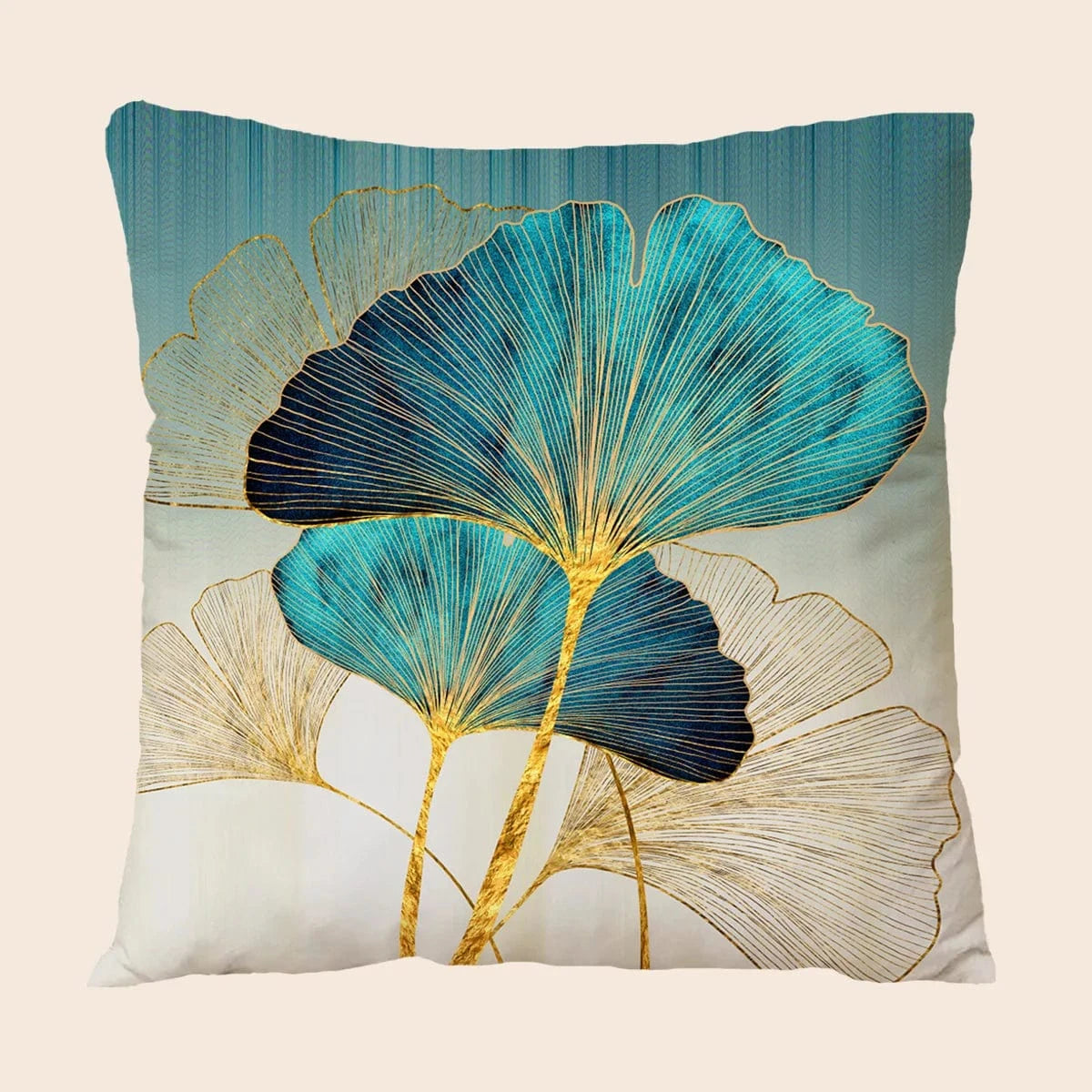 Coussin décoratif aux motifs de feuilles bleues et dorées, posé sur un canapé élégant