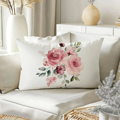 Coussin décoratif blanc avec motif floral rose, posé sur un canapé beige dans un salon lumineux
