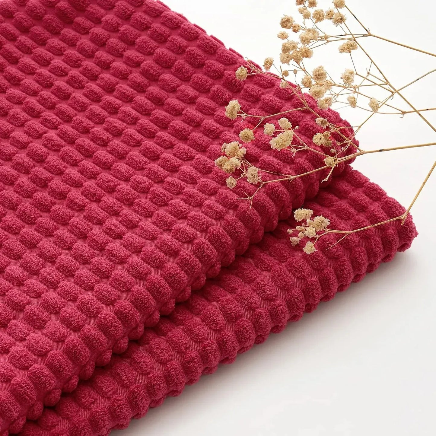 Housse de coussin rouge texturée avec motifs en relief, idéale pour un décor chaleureux dans un salon