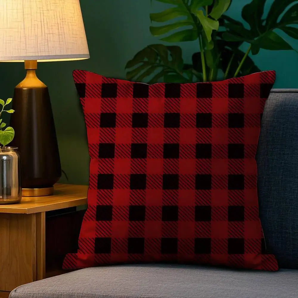 Coussin décoratif en tartan rouge et noir sur un canapé, ajoutant une touche chaleureuse au salon