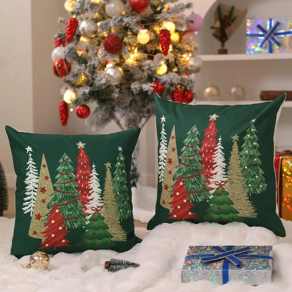 Coussins décoratifs avec motifs de sapins colorés sur fond vert, posés sur un tapis moelleux près d'un sapin de Noël