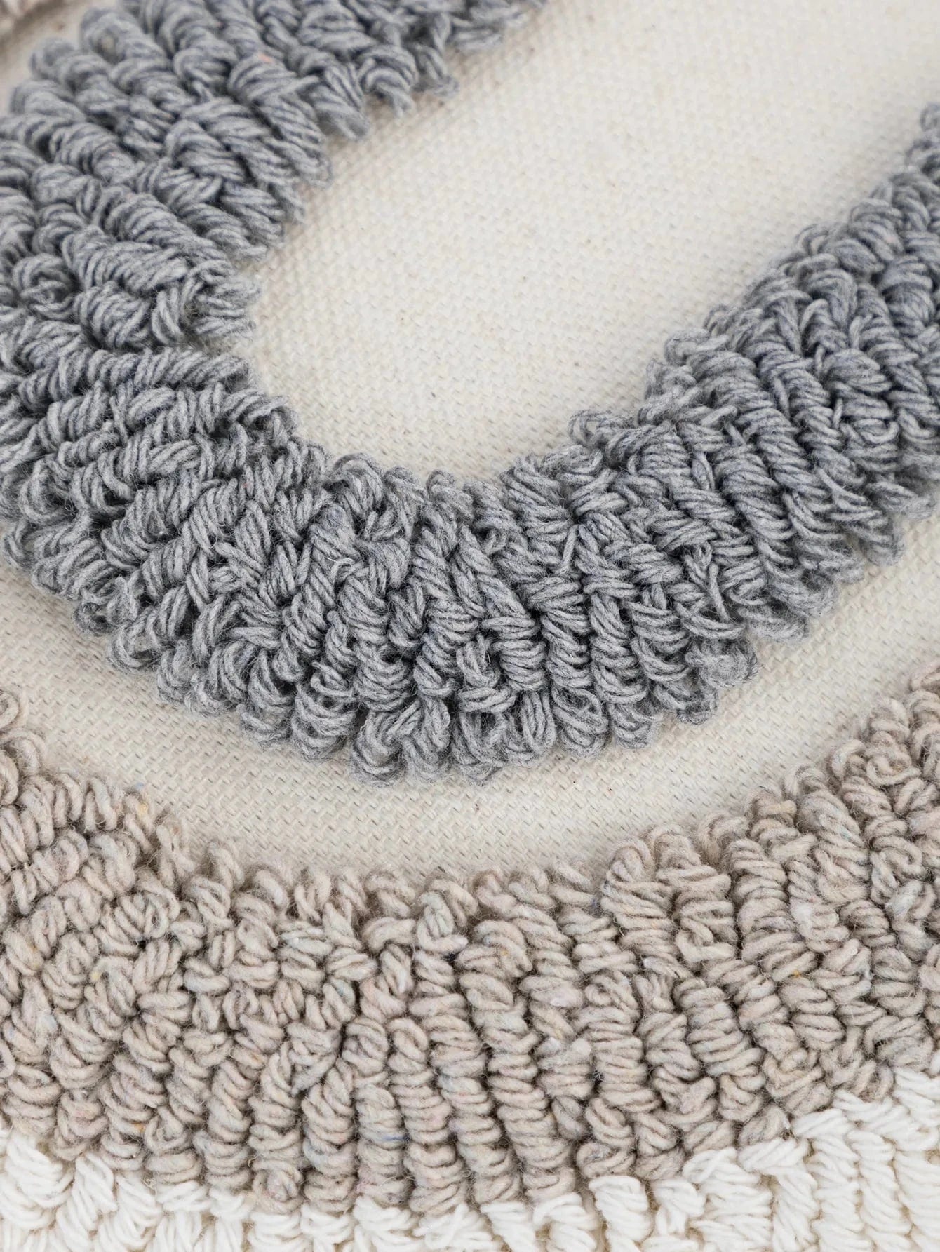 Housse de coussin décoratif en coton beige avec motifs en relief gris, idéale pour un canapé moderne