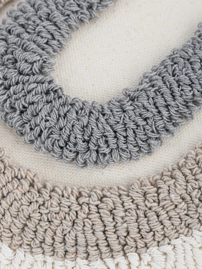 Housse de coussin décoratif en coton beige avec motifs en relief gris, idéale pour un canapé moderne