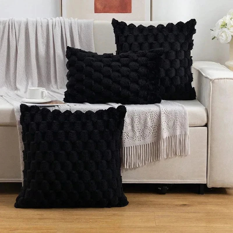Coussins décoratifs noirs en tissu texturé sur un canapé, ajoutant une touche moderne et élégante à l'intérieur