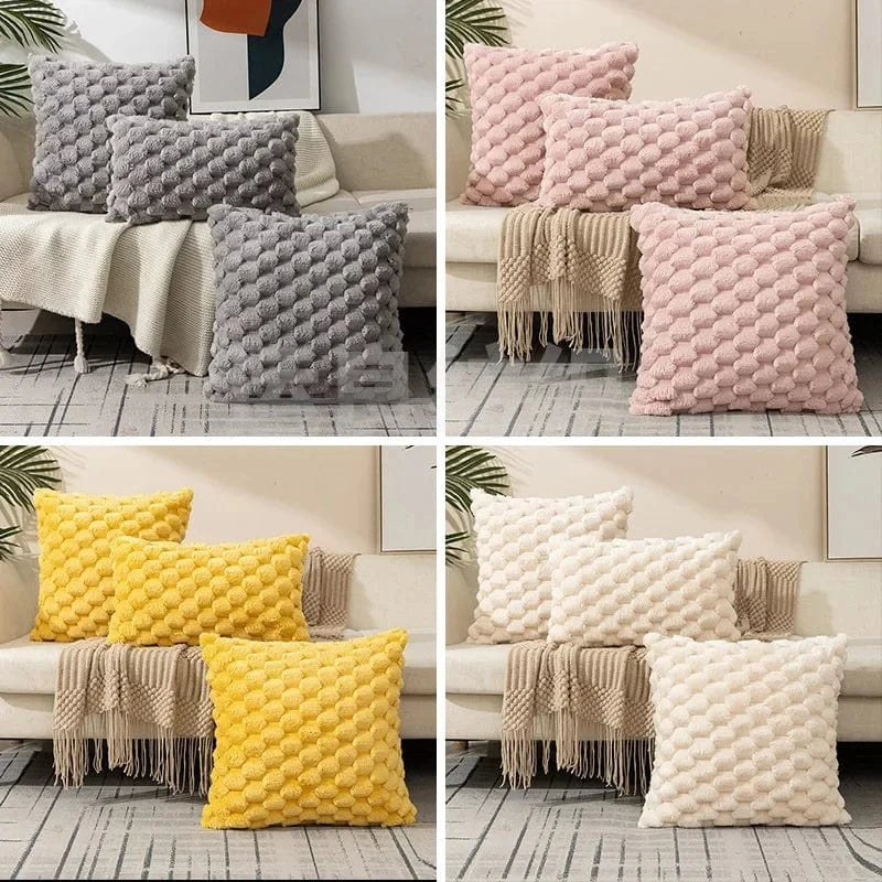 Coussins décoratifs aux textures douces et colorées, disposés sur un canapé avec un plaid beige