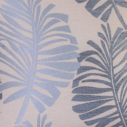Housse de coussin décoratif avec motifs de feuilles tropicales en bleu sur fond beige, idéale pour un canapé ou un