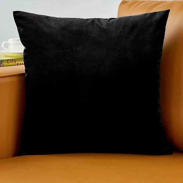 Coussin en velours noir posé sur un canapé marron, ajoutant une touche élégante à la décoration intérieure
