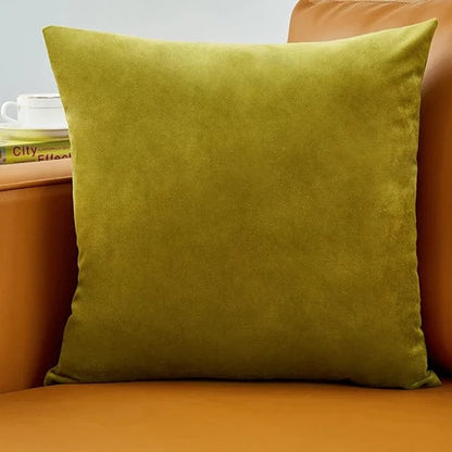 Coussin déco vert en velours posé sur un canapé marron, ajoutant une touche d'élégance et de douceur à l'intérieur
