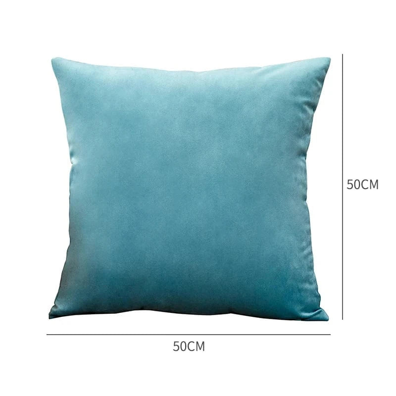 Coussin décoratif en velours bleu, posé sur un canapé, ajoutant une touche d'élégance à la décoration intérieure