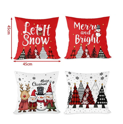 Quatre coussins décoratifs aux motifs de Noël, rouges et blancs, avec des arbres et des personnages festifs sur un canapé