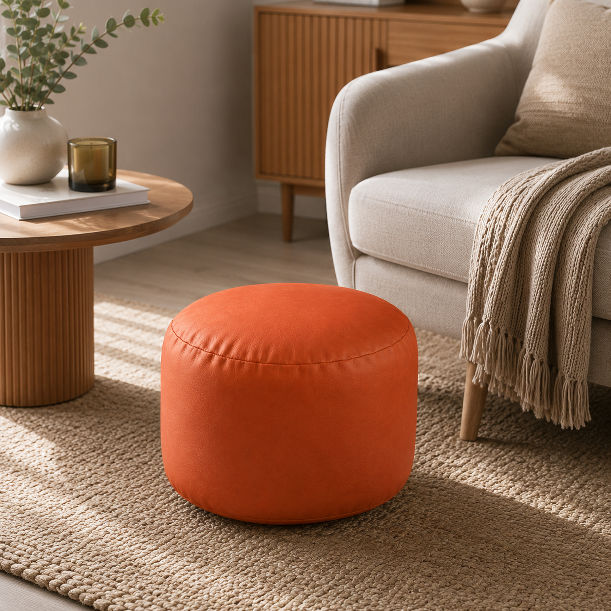 Petit pouf rond orange utilisé comme repose-pieds près d’un fauteuil