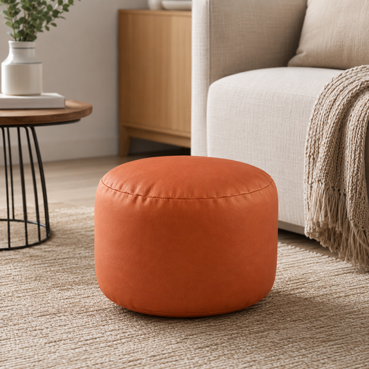 Petit pouf rond repose-pieds effet cuir orange dans un salon