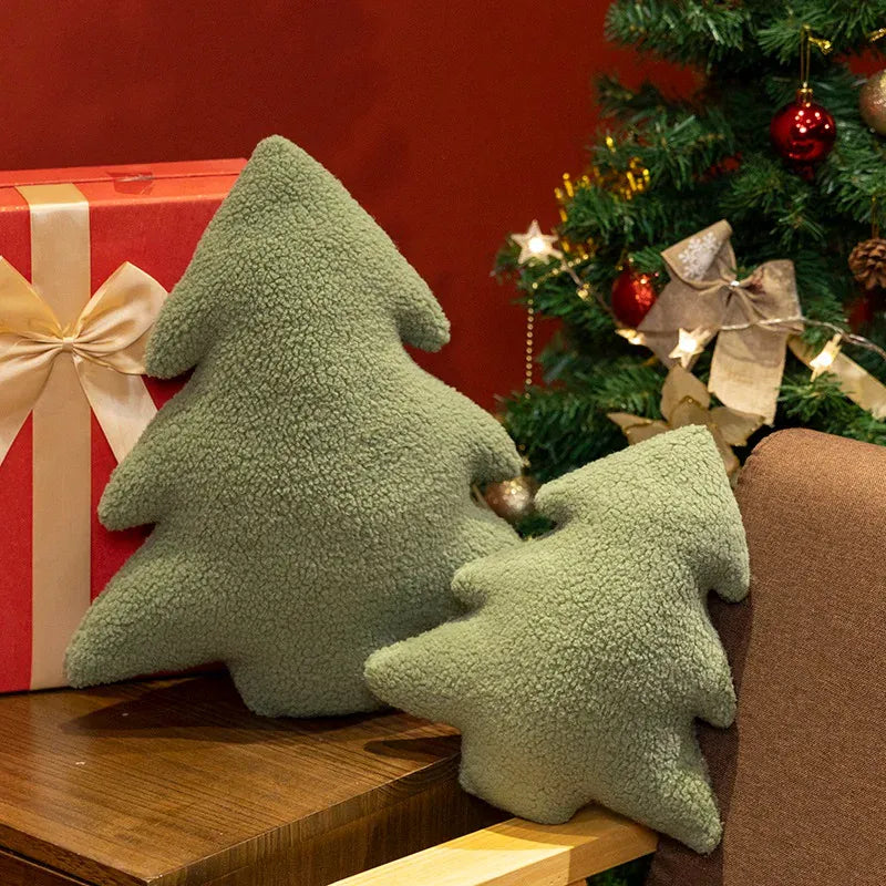 Coussins en forme de sapin de Noël, en tissu vert pelucheux, décorant une table en bois près d'un sapin